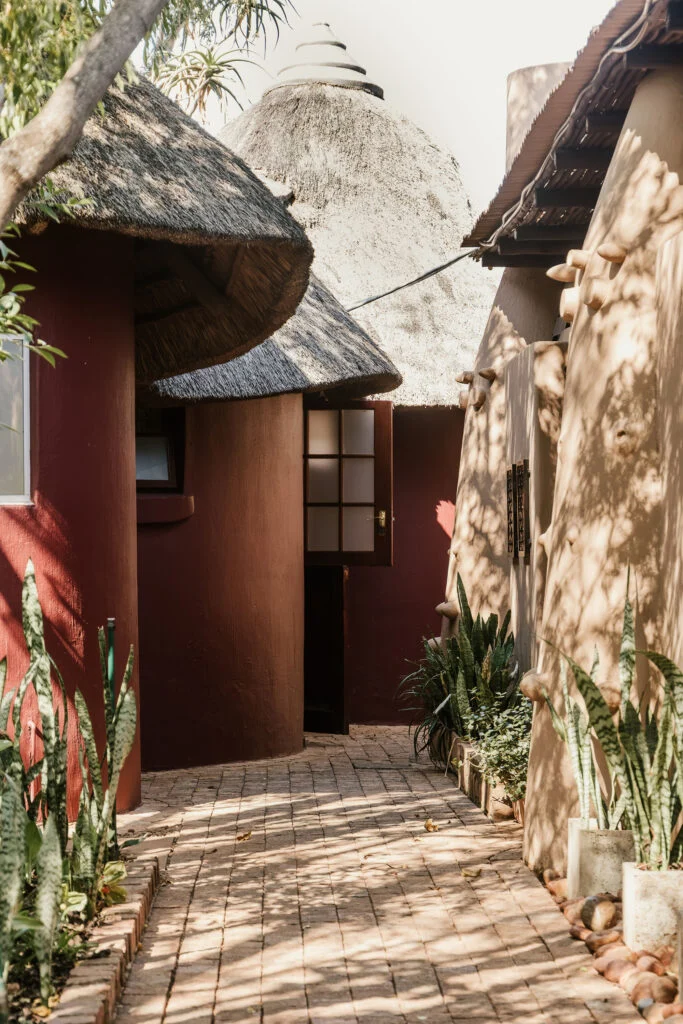 Shaded brick walkway beside a thatched guest room at Casa Kaya.