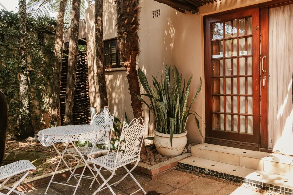 White garden table and chairs beside a guest room at Casa Kaya.